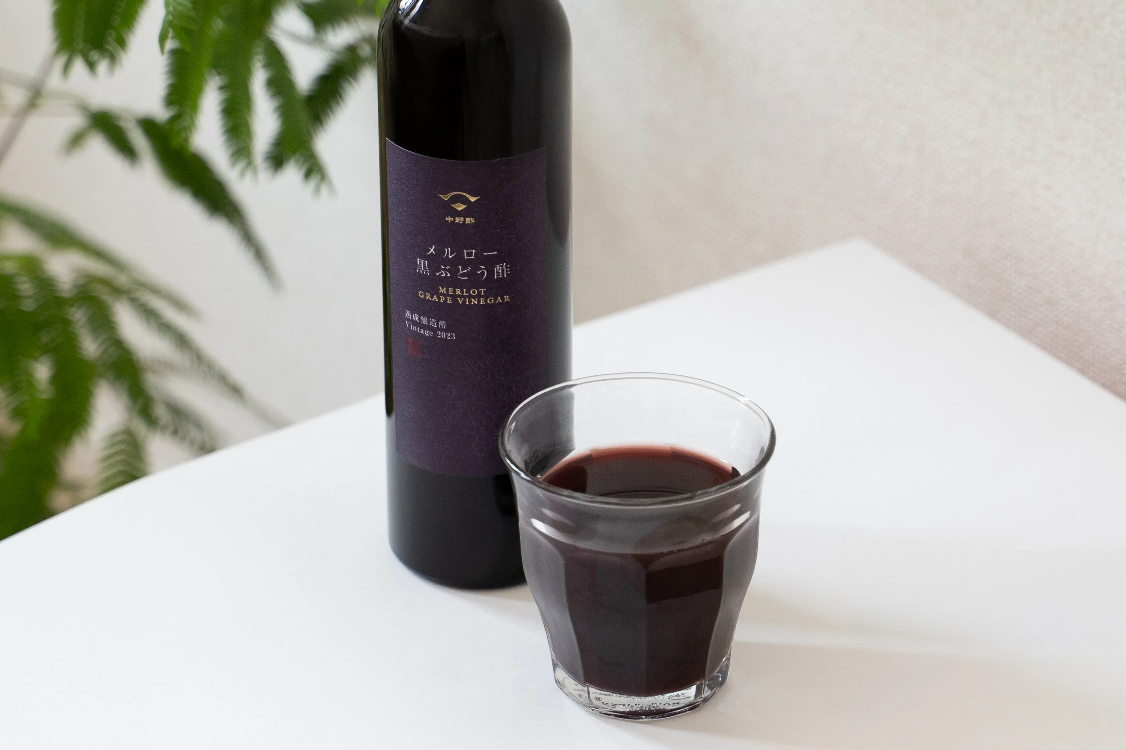 黒ぶどう酢の瓶とグラスを並べた使用イメージ