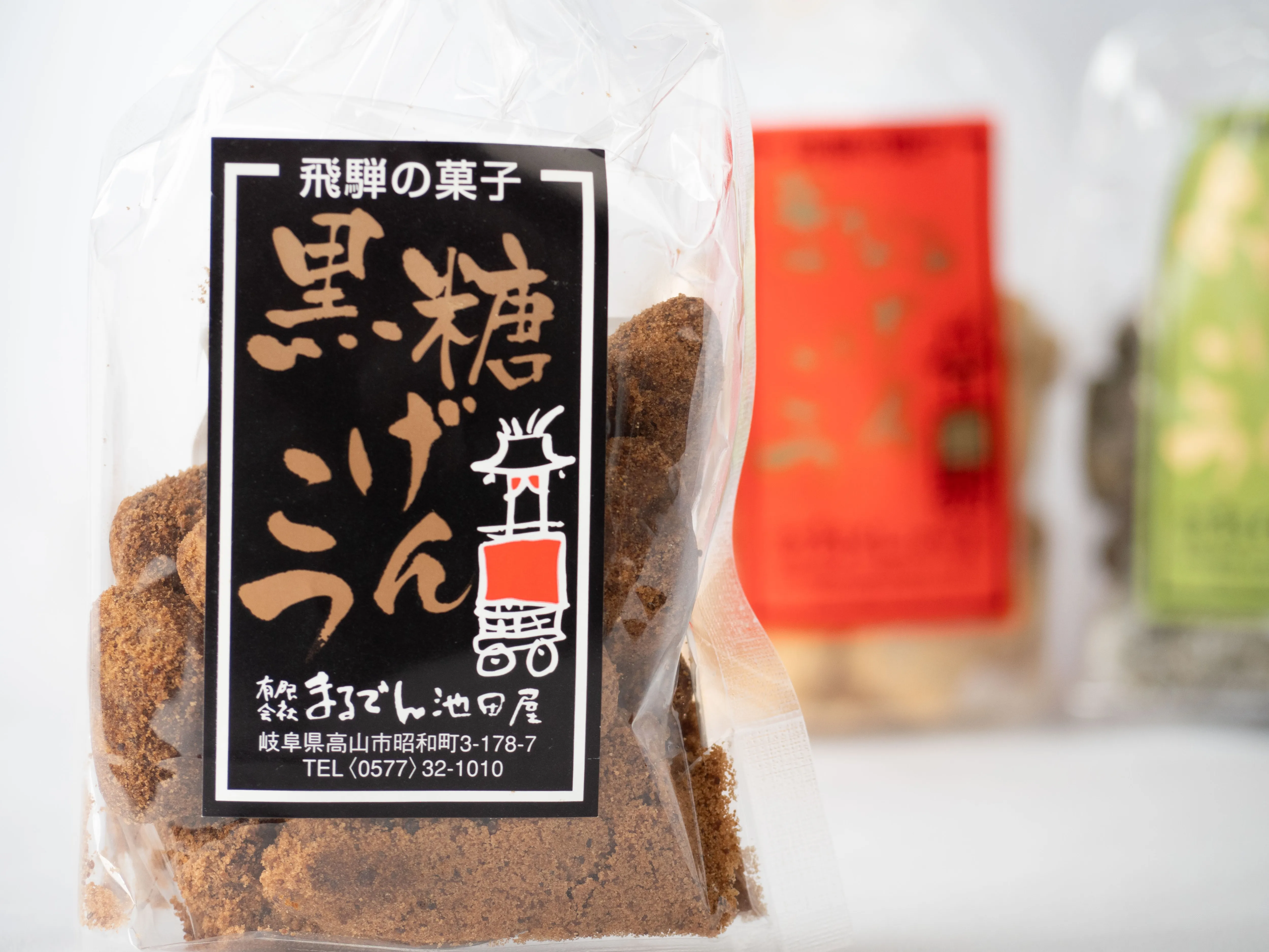 手前の黒糖げんこつの黒いラベルと、奥に並ぶ赤・緑のシリーズ商品